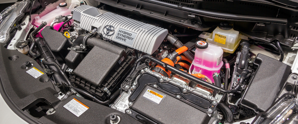 Hybrid Car Maintenance in York, PA at Quality Service Center: Image of technicians gathered around a black open hybrid car, examining and discussing various components and maintenance procedures, emphasizing the importance of professional hybrid vehicle care.