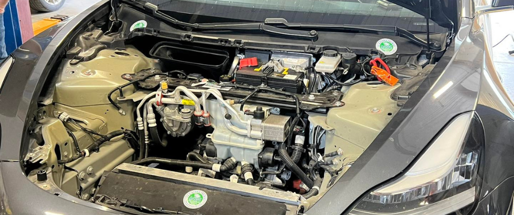 Hybrid A/C Service in York, PA by Quality Service Center: A close-up view of the engine bay of a hybrid car undergoing air conditioning maintenance, emphasizing the importance of keeping the A/C system in optimal condition for summer driving.