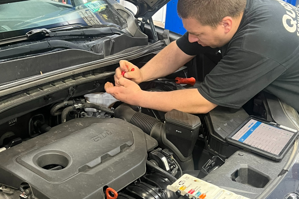 Car maintenance in York, PA by Quality Service Center. Mechanic using tablet-based digital vehicle inspection during back-to-school car care service.