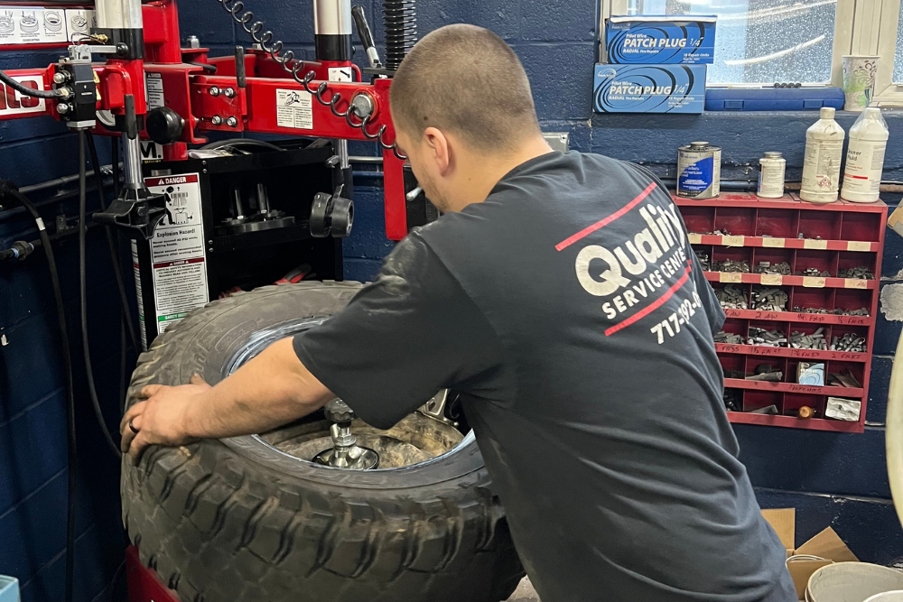 Tire Rotation in York, PA At Quality Service Center. Mechanic performing a tire rotation on a vehicle in auto repair shop
