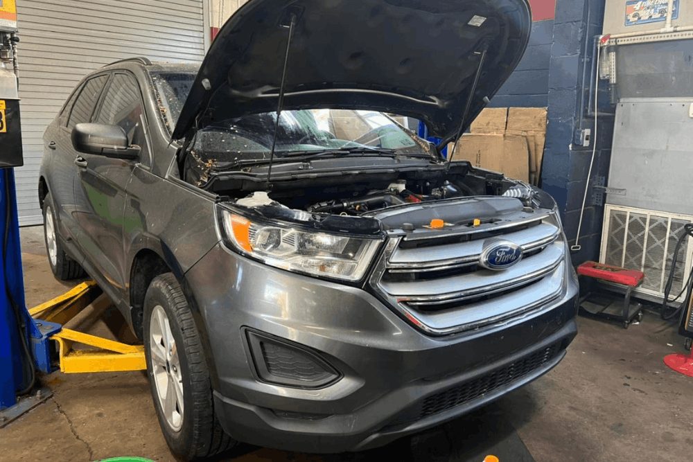 Domestic auto repair in York, PA, at Quality Service Center. Image of Ford SUV with the hood open in a professional auto repair shop, receiving expert domestic vehicle diagnostics, maintenance, and repair services.